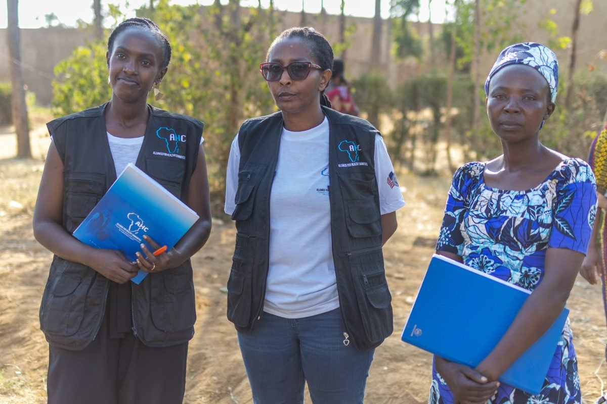 Three AHC field staff and a community member at an outreach site