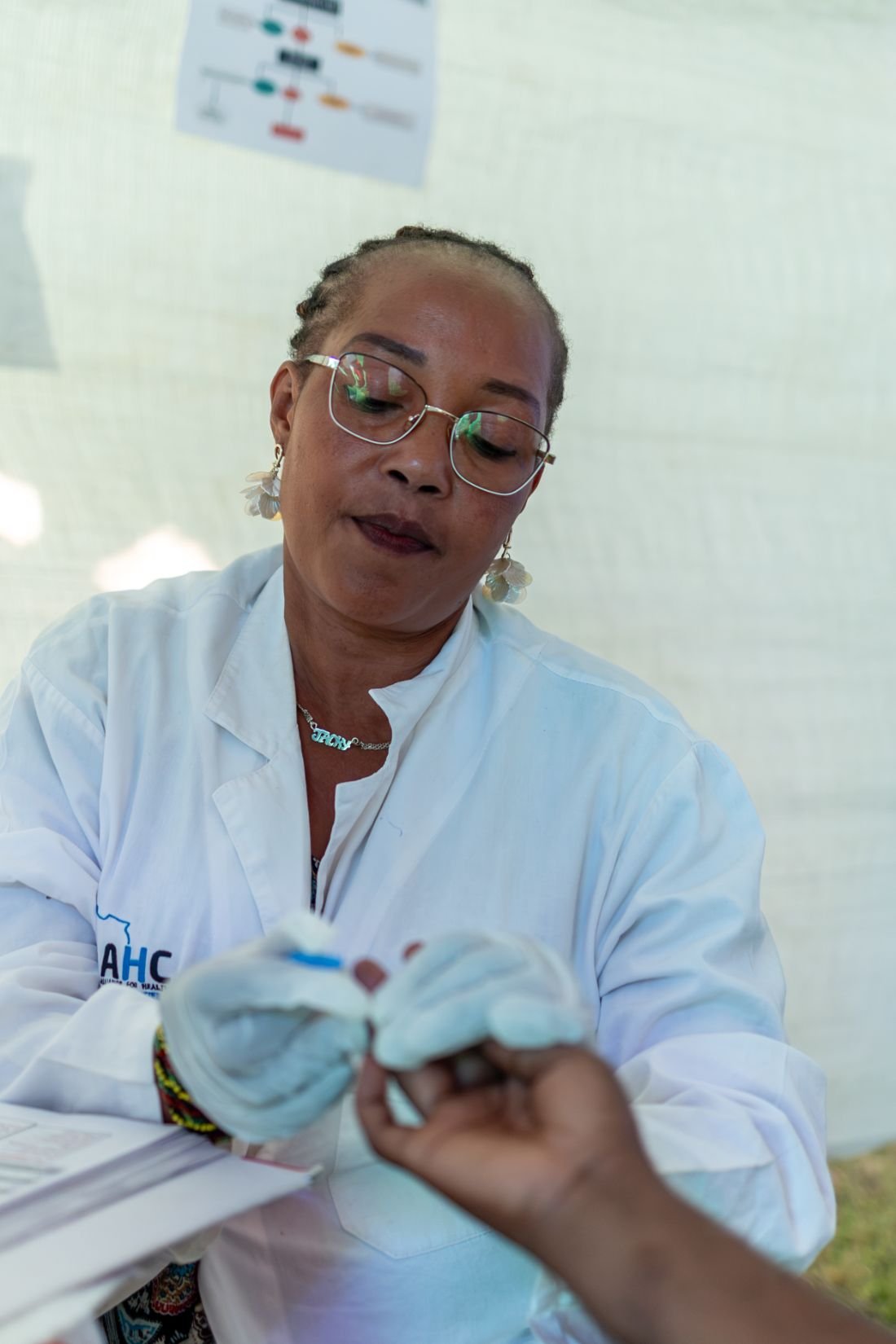 An AHC clinician taking a blood sample at an outreach tent